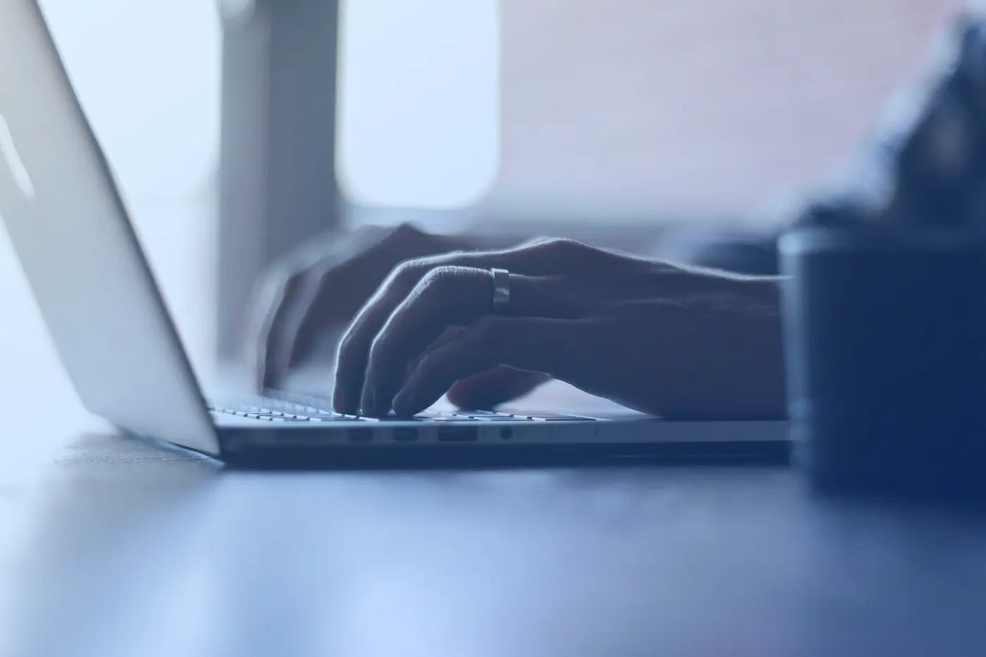 Hands typing on a laptop